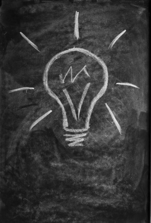 light bulb drawn with chalk on blackboardの写真素材