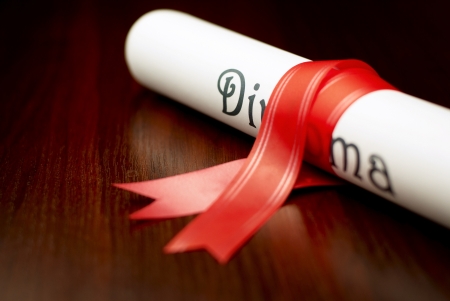 Diploma with red ribbon on the tableの写真素材