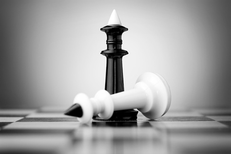 white king fell in front of black on the chessboardの写真素材