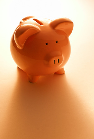 Backlit pink ceramic piggy bank standingの写真素材