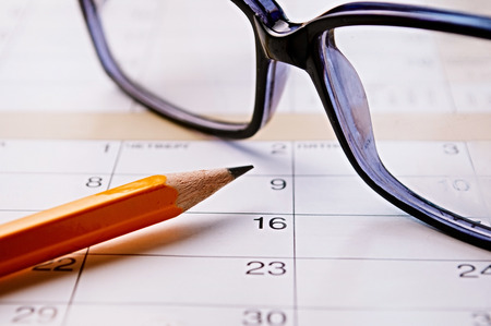 Calendar, pencil and glasses for planning important things and to set a date.の写真素材