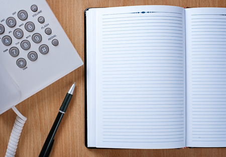Clean Notebook and Pen for Appointments on Wooden Table of Telephone Operator.