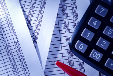 Close up Black Calculator and Red Pen on Top of Paper Reports with Numerical Prints. Emphasizing...
