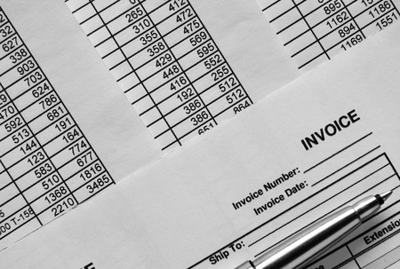 Close up Shot of Conceptual Silver Ballpoint Pen on Top of Invoice Papers Printed with Figures.の写真素材