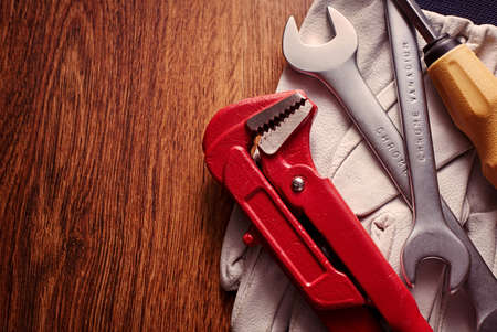 Close Up Hand Tools and Pair of Gloves on Top of a Wooden Table with Copy Space on Left Side.の写真素材