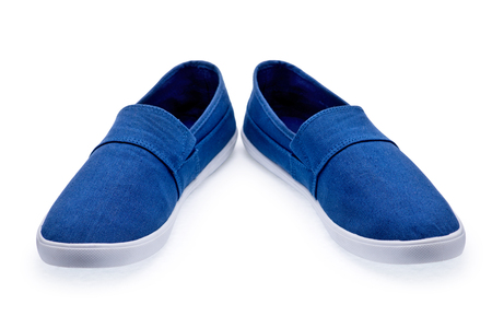 A pair of blue tennis shoes without laces on a white backgroundの写真素材