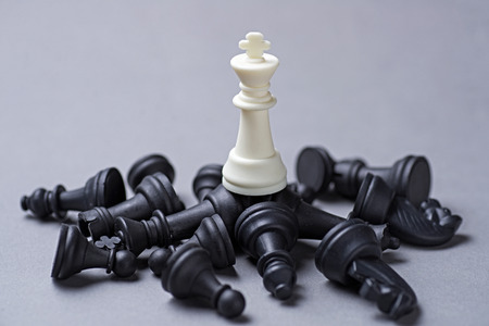 White king chess piece surrounded by fallen black pieces, success conceptの写真素材