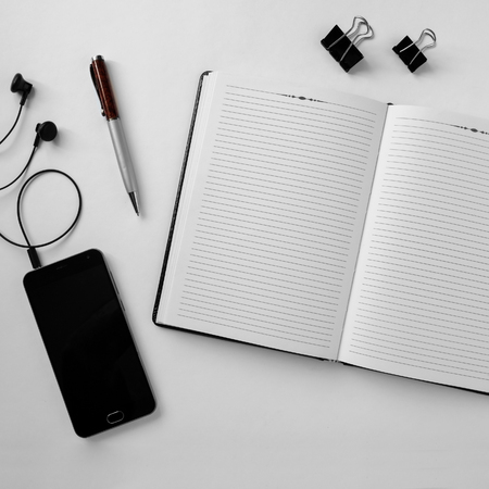 Top view of an office desk with stationery items and electronic gadgetsの写真素材