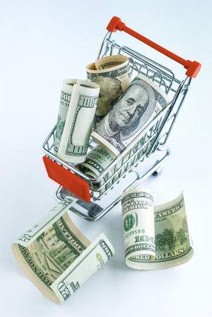 The supermarket cart is filled with American dollarsの写真素材