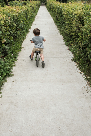 Happy boy riding a small bicycle in the parkの写真素材