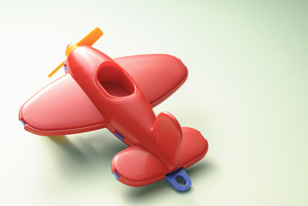 Red childrens plane on a green gradient backgroundの写真素材