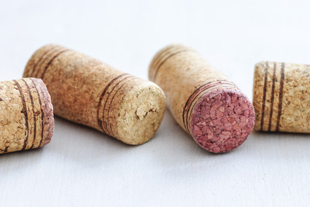 Close-up of several used red wine bottle corks sitting on white surface and viewed in detail from high angleの写真素材