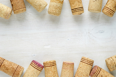 Set of used wine bottle corks, sitting on white table surface, viewed from above with copy space