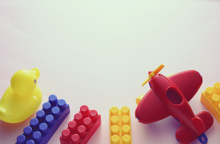 Border of colorful plastic kids toys with building blocks, airplane and duck on white with copy spaceの写真素材
