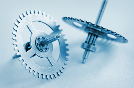 Two steel gear wheels on a grey background conceptual of industry, enginering, manufacturing or...
