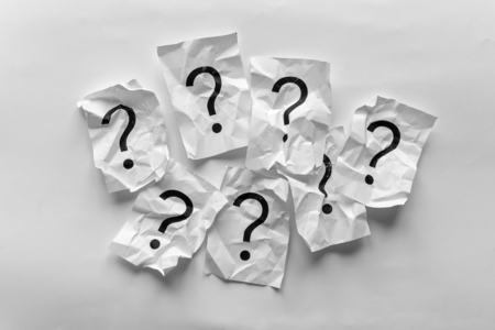Border of crumpled question marks on cards over a white background with copy space in a conceptual...