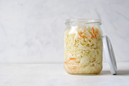 Transparent jar filled with juicy sauerkraut composed on white backgroundの写真素材