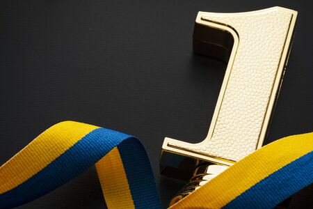 Number one gold award winner and yellow-blue ribbon on a yellow backgroundの写真素材