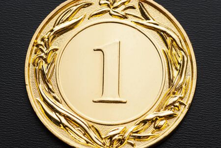 Close-up of a golden medal for the number one champion as award and official recognition of the achievementの写真素材