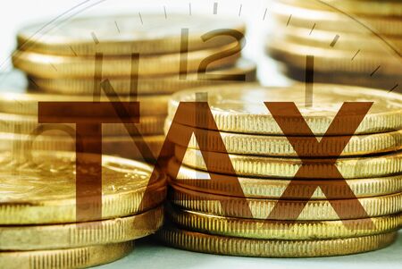 Gold coins tax concept with overlaid clock marking the deadline for payment and submissionの写真素材