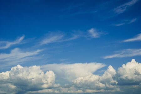 White cumulus clouds against blue sky, viewed from low angle. Cloudscape without horizon visible