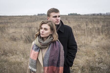 Young couple walking in winter countryside on a cold bleak day standing