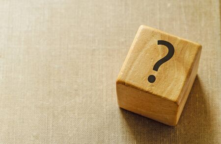 Natural wooden cube with question mark on topの写真素材