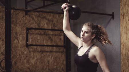Young woman working out with a kettlebell weight