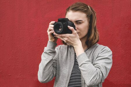 Young woman photographer focusing on the viewerの写真素材