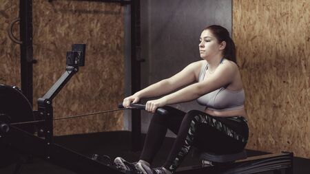 Young woman working out doing resistance pulls