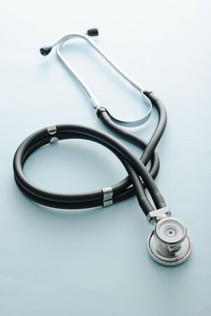 Coiled stethoscope on a blue background conceptual of cardiology and medicine or the Covid-19 pandemicの写真素材