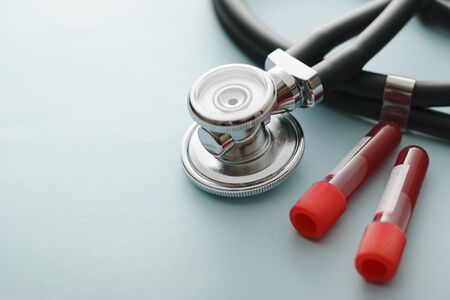 Lab test tubes with blood samples and stethoscope in a concept of diagnosis for the coronavirus or Covid-19 during the pandemic, medicine and healthcareの写真素材