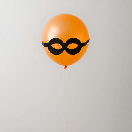 Balloon orange and black glasses. Party or hidden criminal concept. Minimal idea.の写真素材