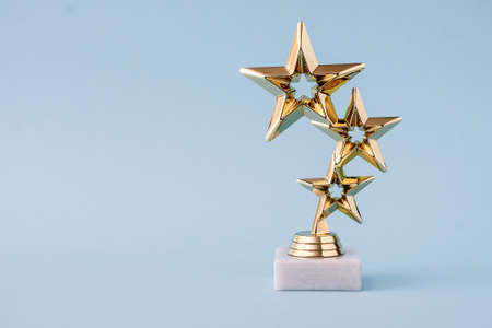 Three star awards for leader and ranking. Golden shiny prize on a pastel blue background.の写真素材