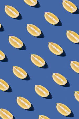 Lemon slices pattern on pastel blue background. Minimal sunlit flat lay.の写真素材