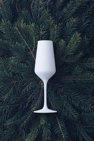 Christmas background with fresh pine branches arranged around the sides as a border on blue with central copyspace for holiday greetingsの写真素材