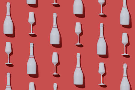 Festive party background with champagne bottles and flutes arranged in an alternating flat lay pattern on red for Valentines, romance, New Year and Christmas themesの写真素材