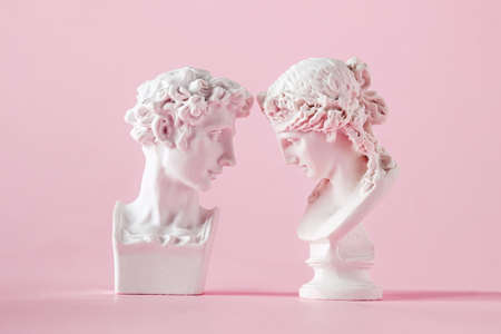 gypsum antique bust of man and woman on pink background, concept of love trust and valentine's dayの写真素材