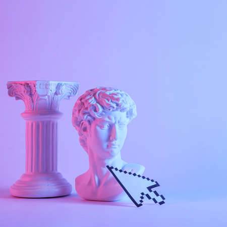 Antique style bust of young Grecian or Roman man with pedestal standing side by side over a purple monotone backgroundの写真素材