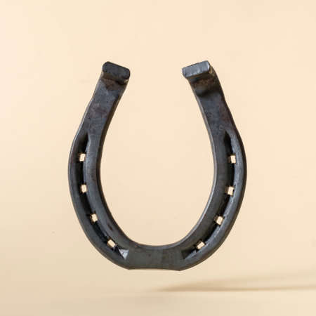 Horseshoe iron on beige background concept of american wild west and rural rodeo or good luck.の写真素材