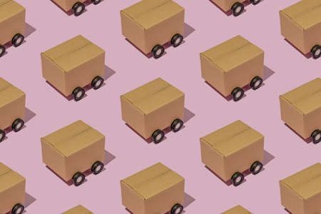 Cardboard boxes on wheels like trucks carry parcels and make deliveries. Minimal logistics pattern.の写真素材