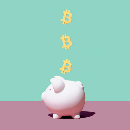 Bitcoin digital virtual mining money falling into piggy bank. Minimal creative concept of crypto currency success and financial crisis.の写真素材