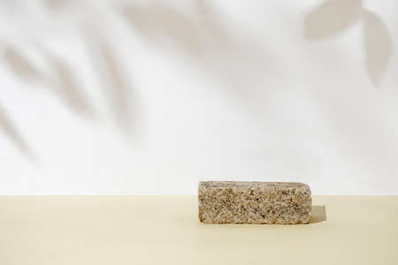 Stone podium pedestal for product demonstration. Leaf shadow and natural pastel background. The concept of new naturalism.の写真素材