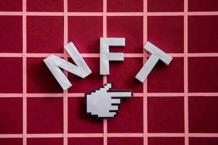 NFT and pixel finger mouse pointer on a red background as a concept of modern online technologies on the blockchainの写真素材