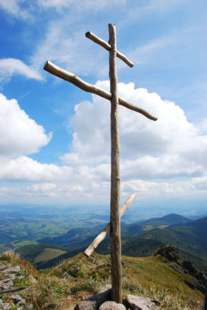 A photo was done at the top of Pikui mountain on the west of Ukraine in Carpathian  Mountains on 26.08.2010. The height of the mountain about 1400 metres. The wooden cross at the top of the montain and a beautiful cloudy sky on a background.の写真素材