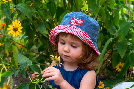 A girl  looks at a yellow flower.の写真素材