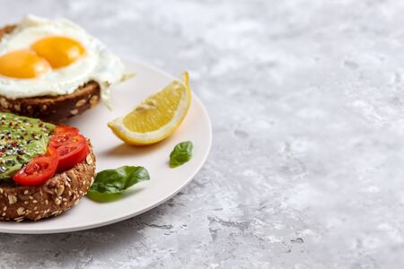 Avocado meal. Healthy egg toast on rye bread with tomato. Vegetarian brunch dish. Delicious green...