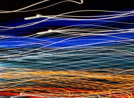 Light wave painting. Night city neon glow effect at velocity. Yellow, blue and gold energy lines...