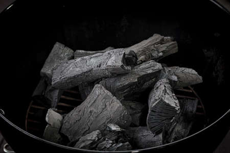 Grill charcoal. BBq coal texture. Barbeque charcoal in brazier, top view. Organic hardwood timber coal, activated fossil carbon, natural ignition for picnic cookingの写真素材