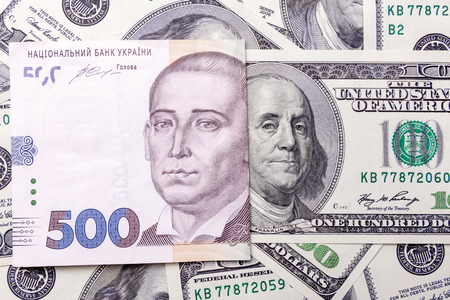 Banknotes are dollars and Ukrainian hryvnias close-up. Portrait of the president on the money. The concept of economyの写真素材